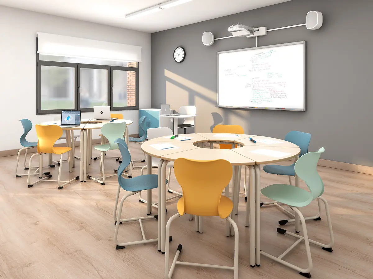 Ergonomische Schülerstühle in Gelb, Blau und Mint an runden Gruppentischen im Klassenzimmer